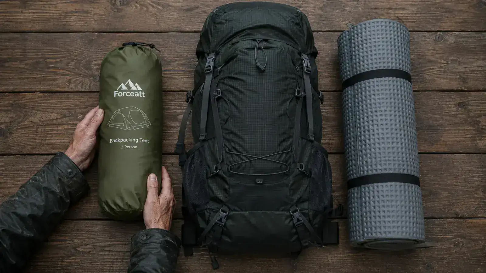 Overhead view of a Forceatt tent packed down with stuff sack alongside a sleeping pad and backpack, showing relative size
