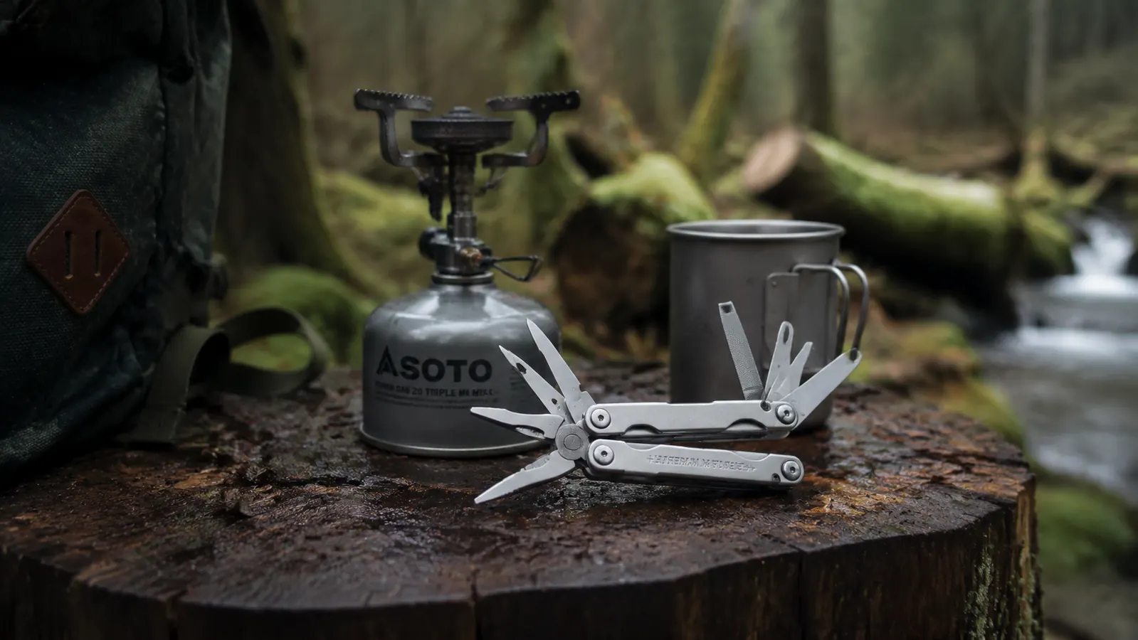 Leatherman Wave+ can-opener and wire-cutter tools open beside a camp stove and tin cup on a log table