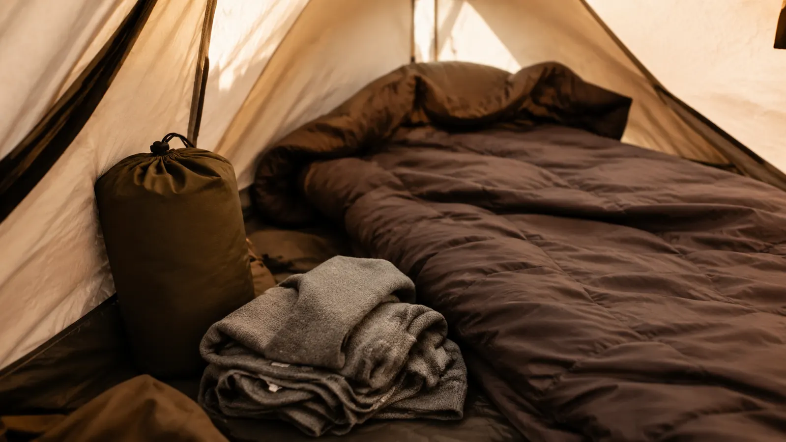 Moisture wicking base layer and dry sleeping bag laid out for inspection inside a backpacking tent