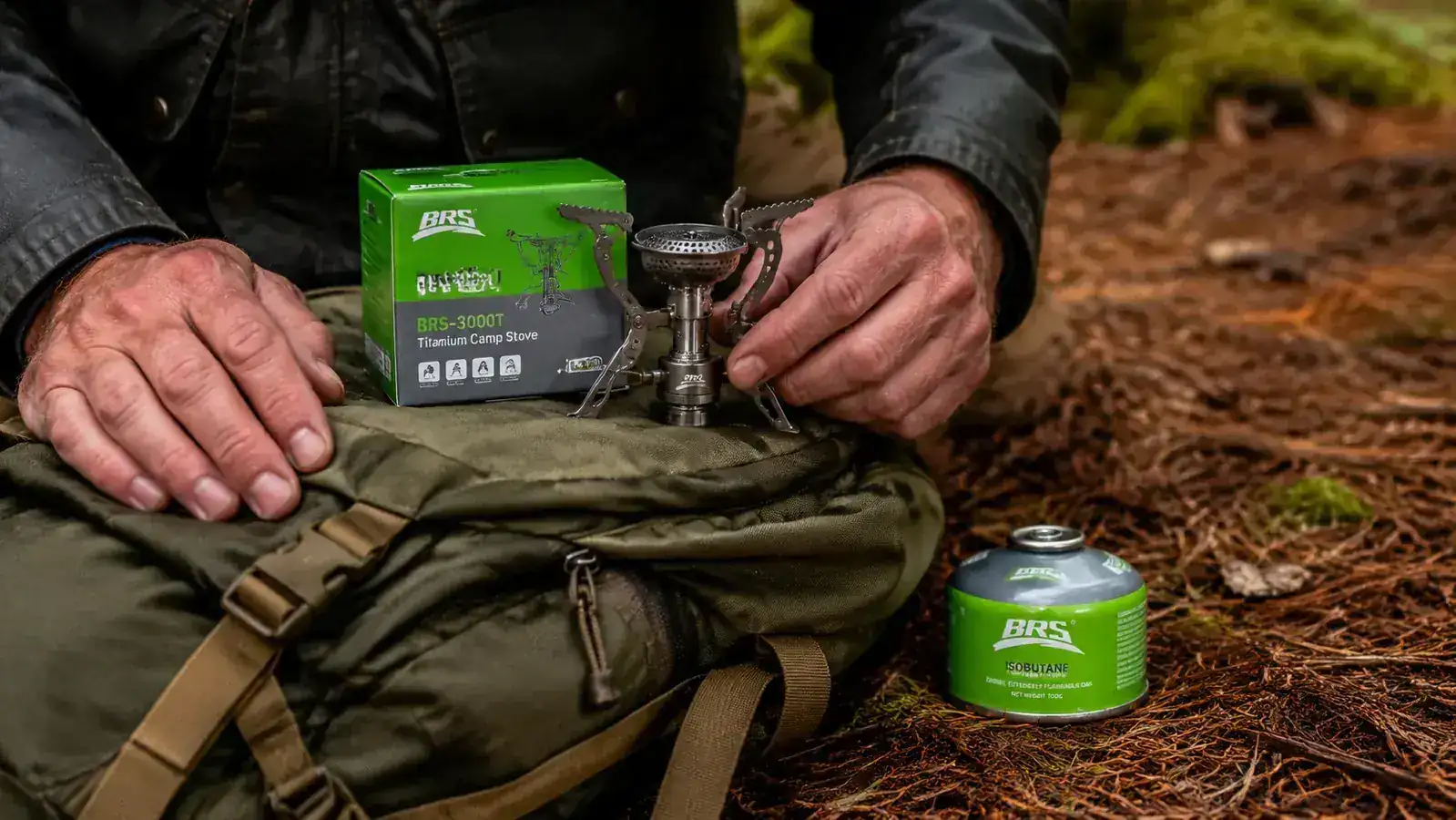 BRS-3000T stove sitting on top of a packed backpack next to a small isobutane fuel canister